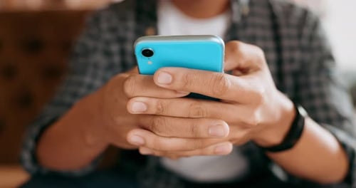 Adult Using a Blue Smartphone Indoors