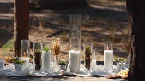 Wedding Party Banquet Outdoors in Forest Dining Table Decorated in Boho Style with Candles White