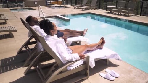 Of Couple in Robes Lying on Pool Loungers