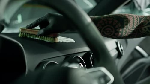 Cleaning the car panel with a brush Salon of a prestigious modern interior detailing luxury car