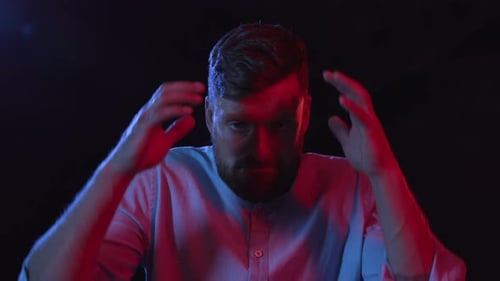 Man with beard expressing anger and shouting indoors