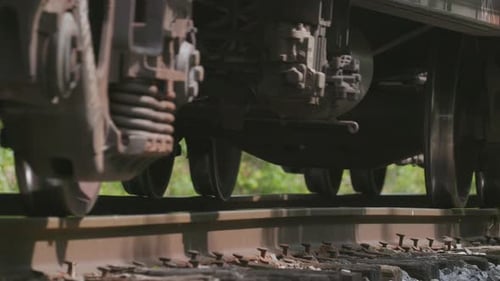 Extreme closeup of freight train wheels on a train track passing by camera.