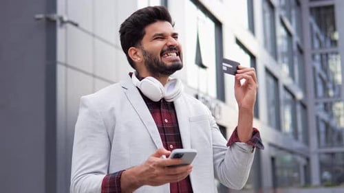 Happy Man with Phone and Credit Card Outdoors