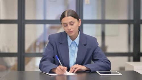 Mixed Race Businesswoman Writing a Letter in Office