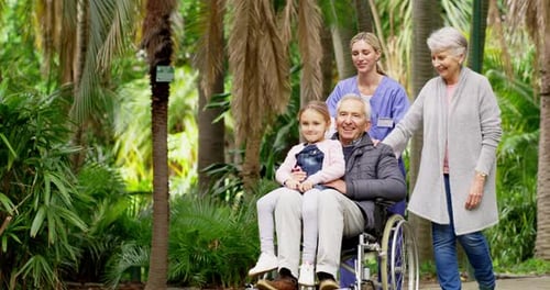 Family Stroll Through Tropical Garden With Wheelchair