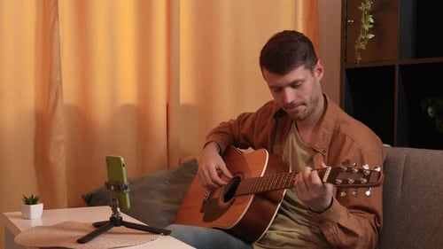 Man Playing Guitar and Singing at Home