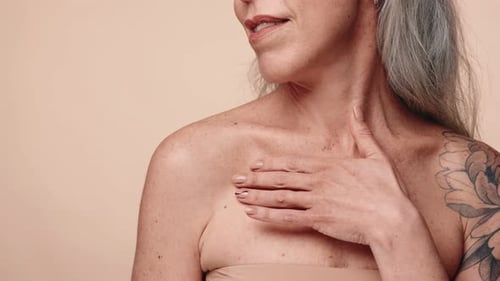 Woman with Gray Hair Touches Shoulder