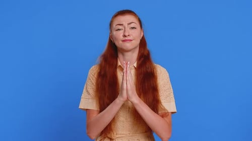 Woman with Red Hair Pleading on Blue Background