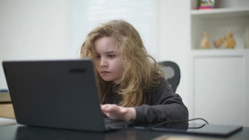 Child Working on Laptop Indoors Child Watching Educational Content on Laptop Child Focused on Laptop