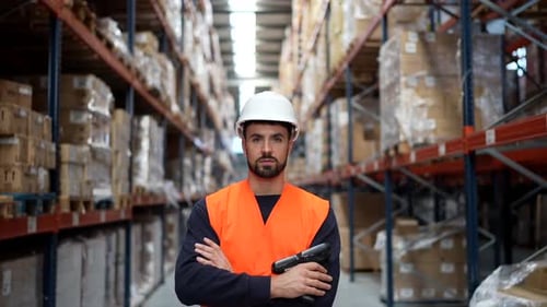 Lagerarbeiter mit Barcodescanner posiert in einem Logistikzentrum