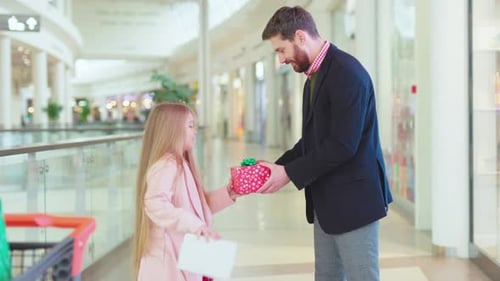 Happy Father and His Daughter Exchanging Christmas Present Boxes Gifts on Shopping Center Talk Dad