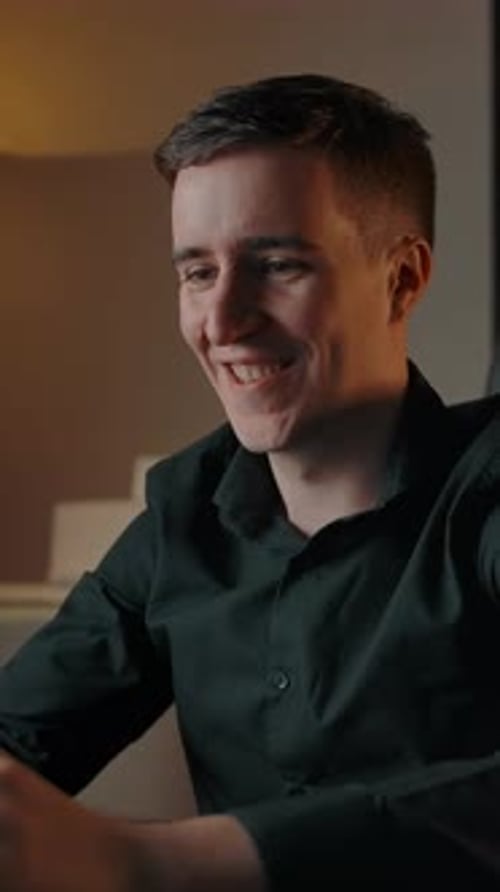 Man Smiling While Using Laptop At Home