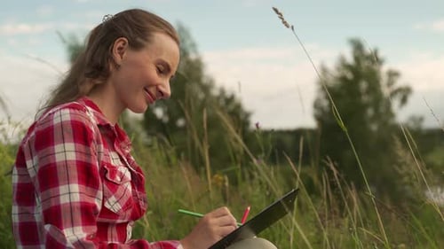 Woman Painting a Picture in Nature a Young Woman with a Pencil in the Grass the Concept of