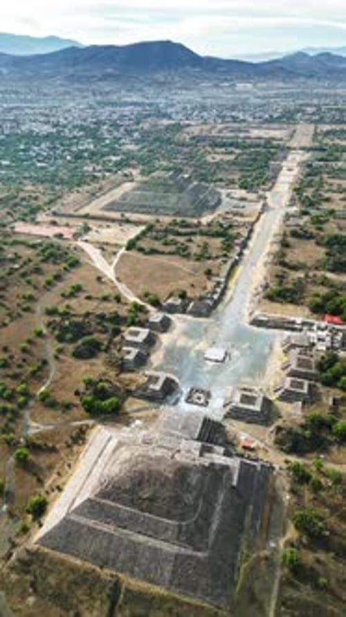 Aerial drone view of the ancient Teotihuacan pyramids with the surrounding Mexican town and mountain