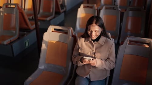 Woman Using Smartphone on Empty Train