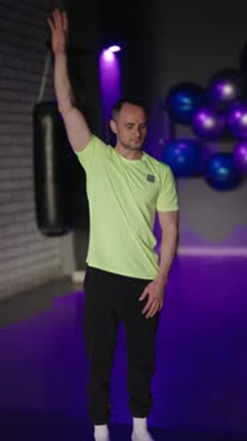 Adult Man Doing Arm Stretching Exercises in Gym