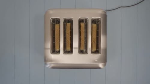 top down view of four Toasted Slices of Sandwich Bread Popping out of Chromed Toaster