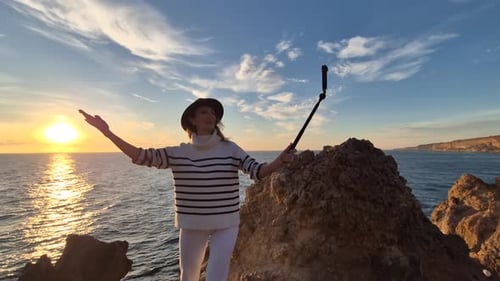 Woman Sunset Ocean Blogger Recording Travel Video on Dramatic Coastal Cliffs
