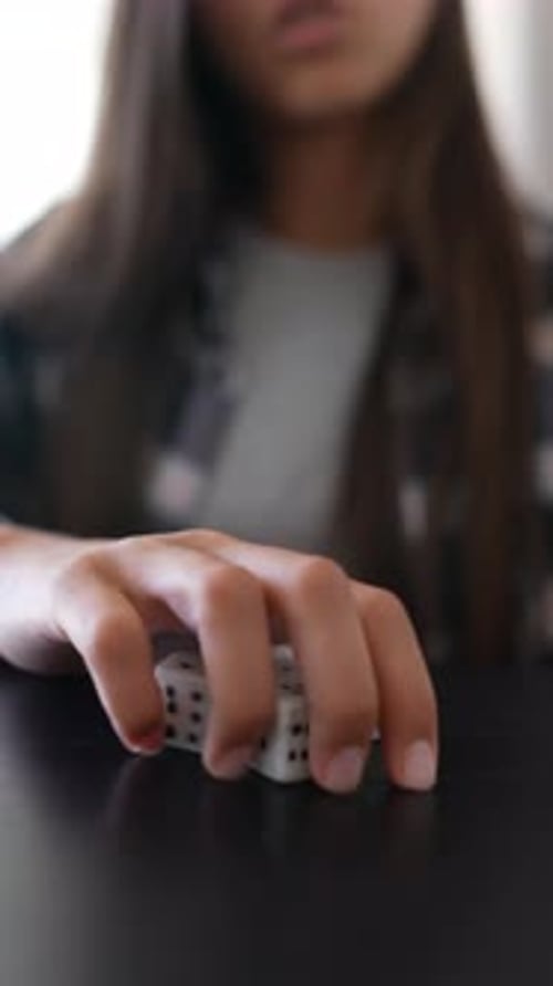 Person Playing Dice at Black Table Focusing on Rolling Dice with Hands Showing Luck and Strategy