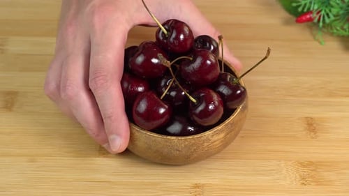La main met un bol avec des cerises mûres. Dessert végétarien à la cerise sucrée