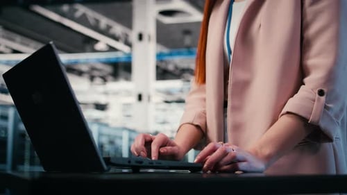 Typing Laptop Close Up and Engineer in Server Farm