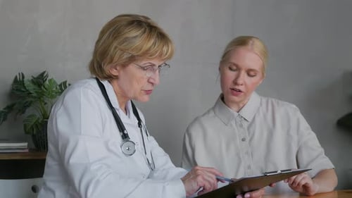 Doctor Reviews Medical Records with Patient