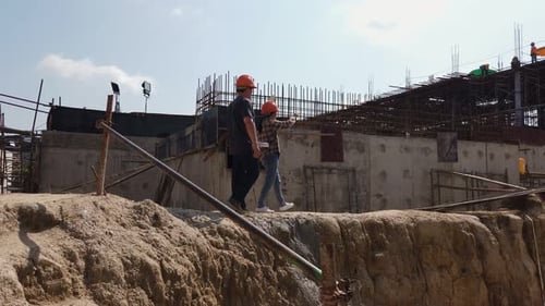 Construction Workers Inspecting Building Project During the Daytime