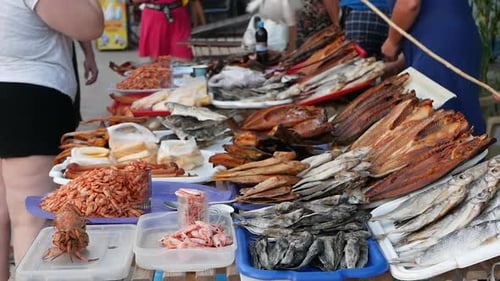V26. Street trade in fish and seafood. The seller drives away flies and other insects from the fish.