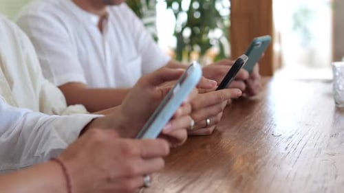 Closeup of the Hands of Men Who Hold Smartphones in Their Hands and Touch the Phone Screen with