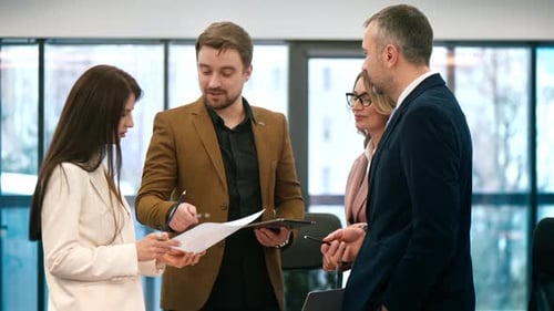 Business meeting in an office, workers discussing business affairs using gadgets and papers with cha