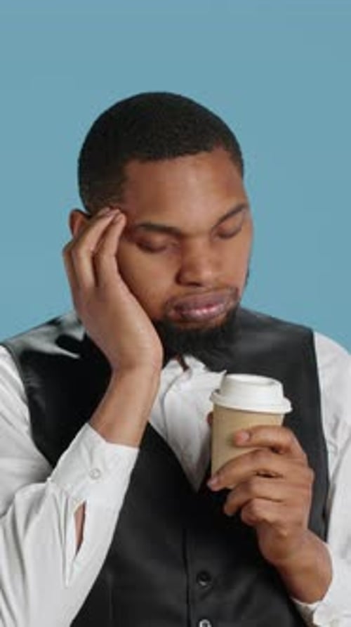 Vertical Video Unwell Hotel Porter Feeling Sick and Drinking a Cup of Coffee