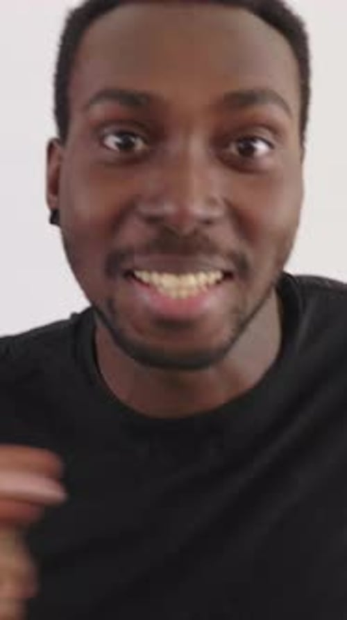 Young man close-up smiling and gesturing to camera