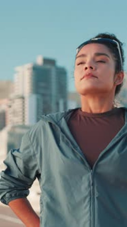 Fitness, runner and tired woman breathing in city for sports break, exercise