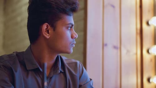 Contemplative Young Man Gazing out Window, Bright Room