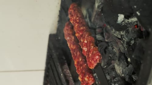 Grill- oder Lammspieße auf Kohlen mit gegrilltem Gemüse. Gegrillte Lammstücke auf Metallspießen.
St