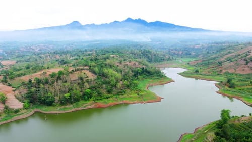Aerial footage of natural lake landscape with forest land and mountain