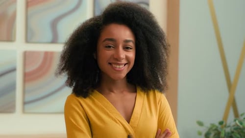 Smiling Woman with Curly Hair Posing Indoors