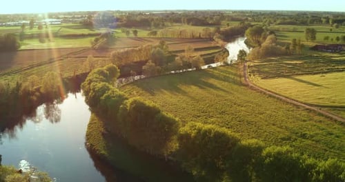 Aerial view of a river surrounded by a magical relaxing place immersed in nature with a sunshine.