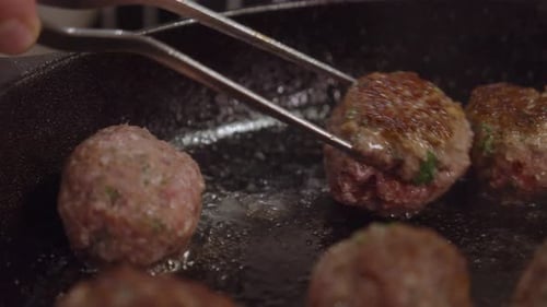 Frying meat balls in hot frying pan. Slow motion.