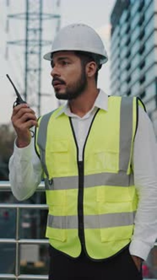 Porträt eines Ingenieurs, der auf der Baustelle per Funk mit Kollegen Kontakt aufnimmt