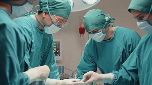Assistenten und Krankenschwestern, die invasive Operationen am Patienten im Operationssaal des Krankenhauses durchführen.