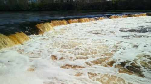 A Beautiful Scene of a Flowing Waterfall with Foamy Rapids in a Scenic River Setting Surrounded By