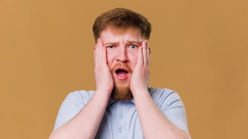 This Young Redhead Guy Looks Shocked and Amazed While Posing for the Camera in a Studio
