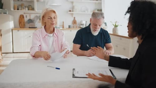 Mature Man and Woman Signing Paper of Insurance of Life or Property Bank Agent Caucasian Married