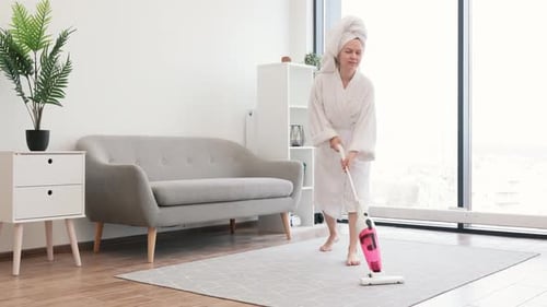 Smiling Woman Vacuums Rug in Bright Apartment
