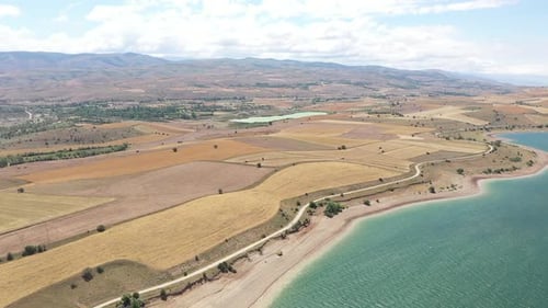 Vue aérienne de la rive asséchée du lac, des collines et des terres agricoles