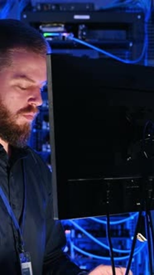 Man Working at Computer in Dark Server Room