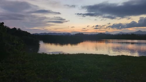 Wide panning shot of panoramic river and scenic clouds during sunset with silhouettes in the Philipp