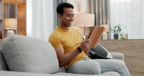 Man Relaxing at Home Using Tablet