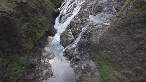 Luftaufnahme von Menschen, die am Stjornarfoss-Wasserfall springen, Island